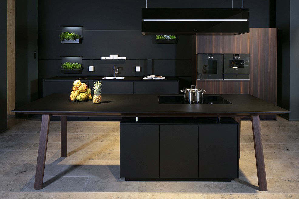 Onyx-schwarze grifflose next125 Küche mit Kochtisch und Geräteschrank mit Echtholzfronten in dunklem Nussbaum
