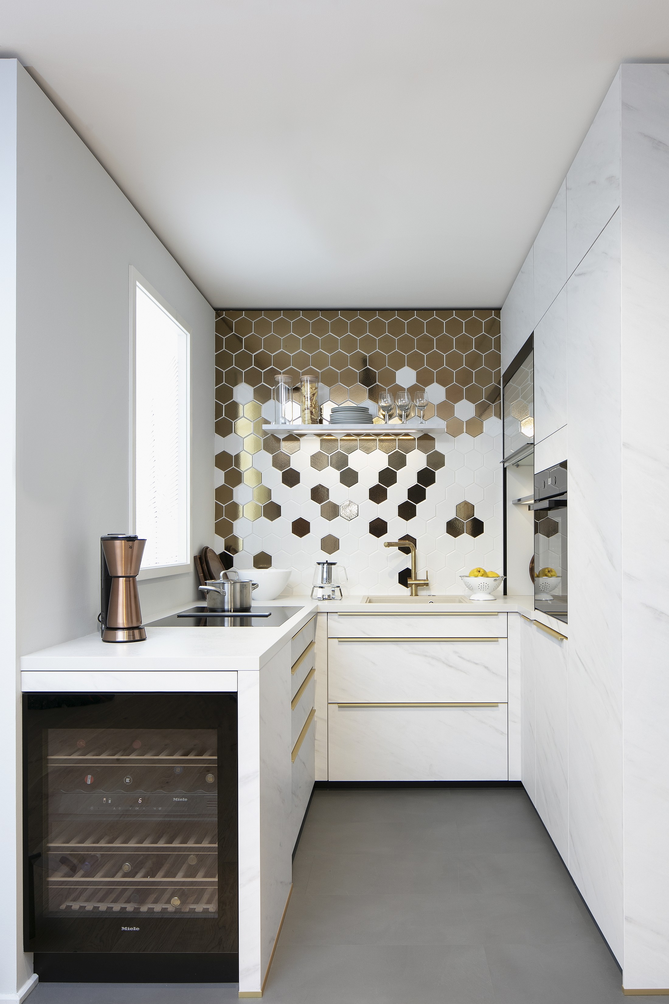 schmale U-Küche mit weißen Marmor-Optik-Fronten von Schüller